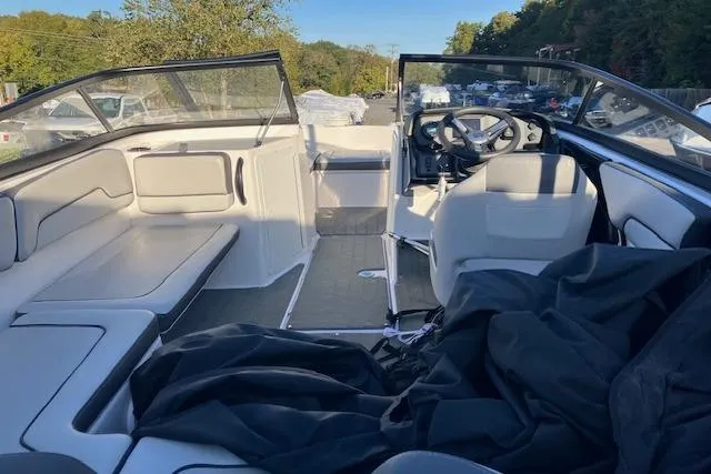 Slide: The Image of 2023 Yamaha Boats AR190 interior with seating and steering wheel, parked outdoors. - 6