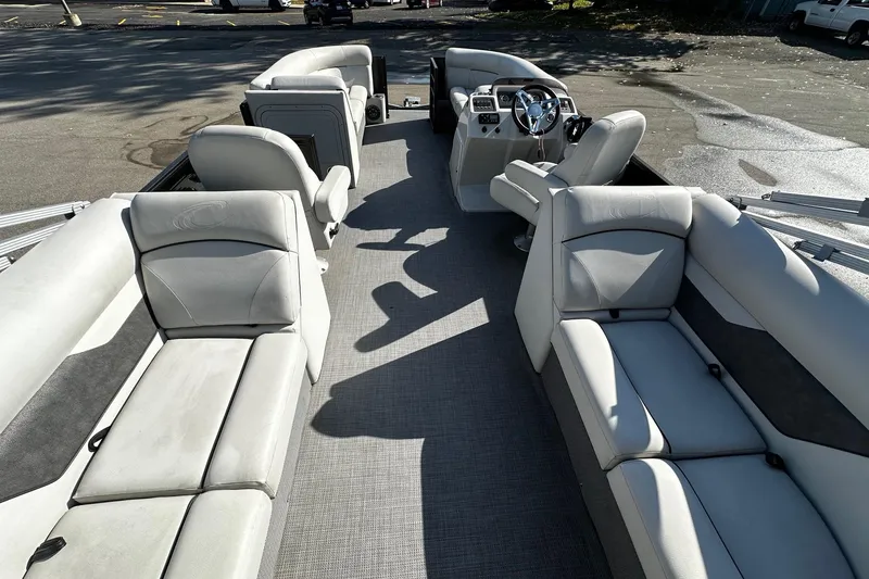 Slide: The Image of 2021 Crest Classic LX 220 SLC pontoon boat interior with plush seating and steering console. - 6