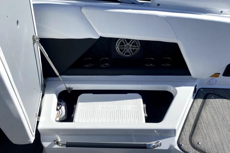Slide: The Image of 2026 Four Winns H6 boat storage compartment with cooler and cup holders. - 10