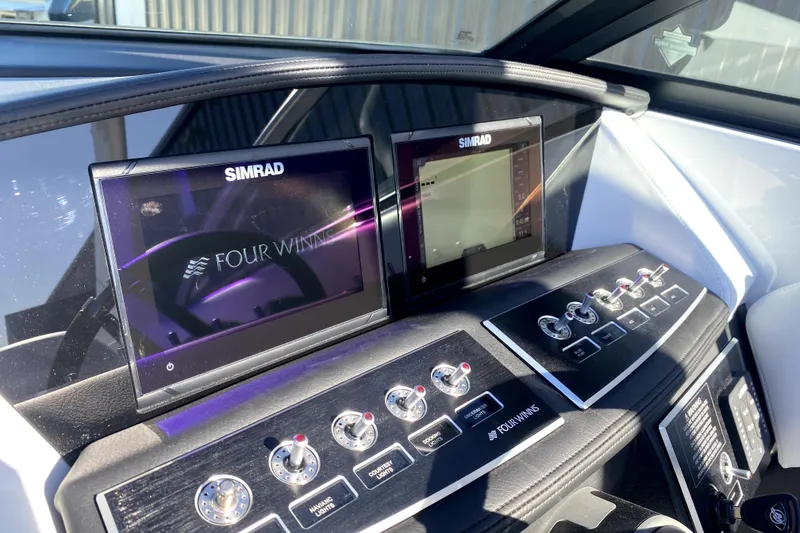 Slide: The Image of Dashboard of 2026 Four Winns H6 boat with Simrad displays and control switches. - 14