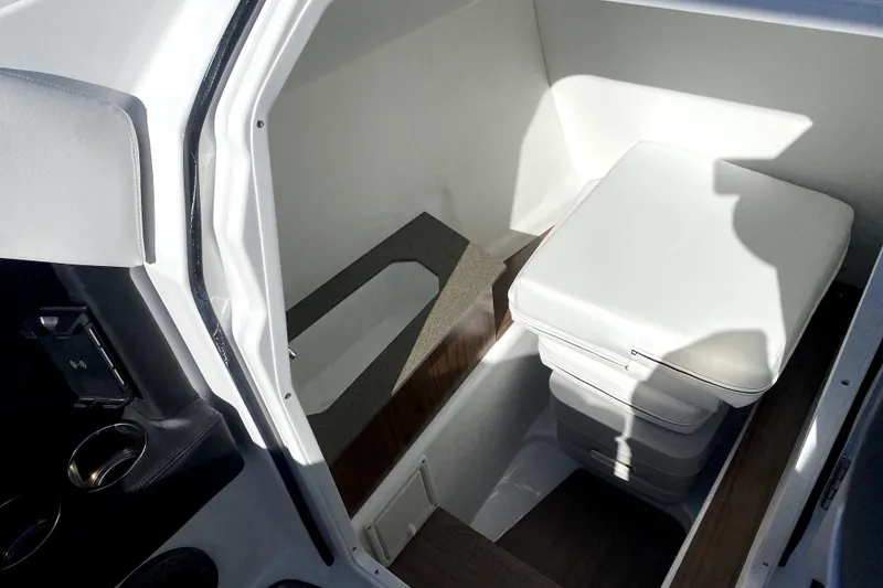 Slide: The Image of Interior of 2026 Four Winns H6 boat featuring a compact storage area with cushioned seating. - 15