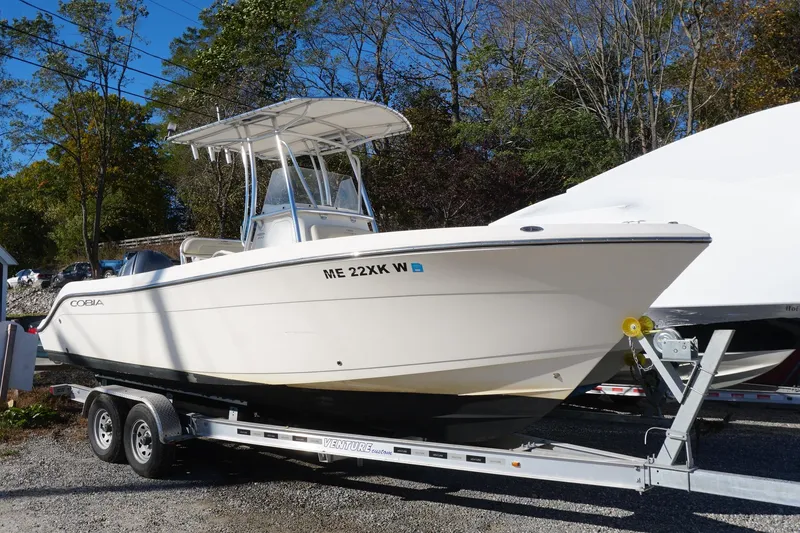 The Image of 2019 Cobia 237 Center Console boat on trailer, parked outdoors. - 1