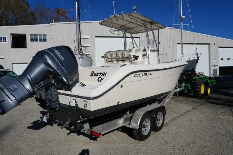Slide: The Image of 2019 Cobia 237 Center Console boat on trailer with Yamaha engine, parked outdoors. - 14
