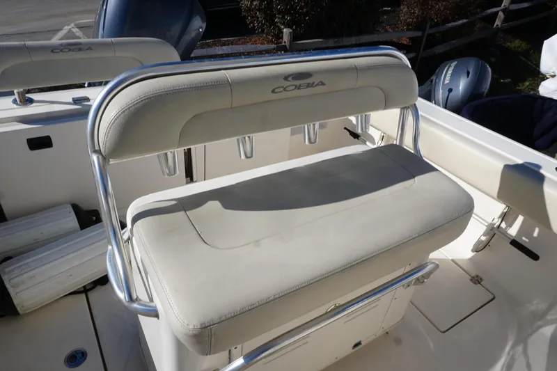 Slide: The Image of 2019 Cobia 237 Center Console boat seat with cushioned backrest and rod holders. - 21