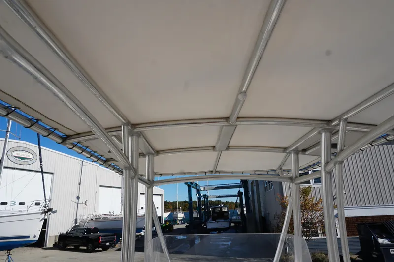 Slide: The Image of 2019 Cobia 237 Center Console boat with T-top frame in a marina setting. - 26