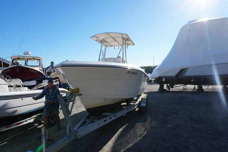 Slide: The Image of 2019 Cobia 237 Center Console boat on trailer in sunny marina. - 9