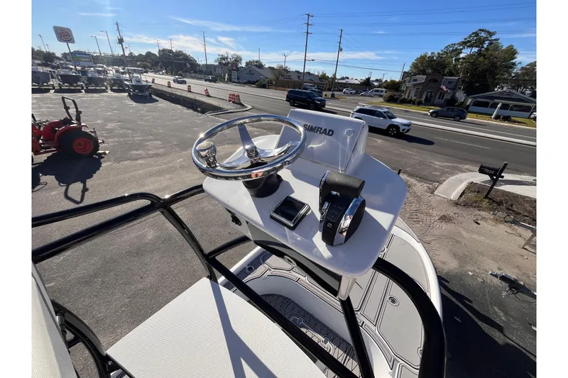 Slide: The Image of 2020 Turner Boatworks 2410 VS helm with Simrad electronics, parked near a busy road. - 22