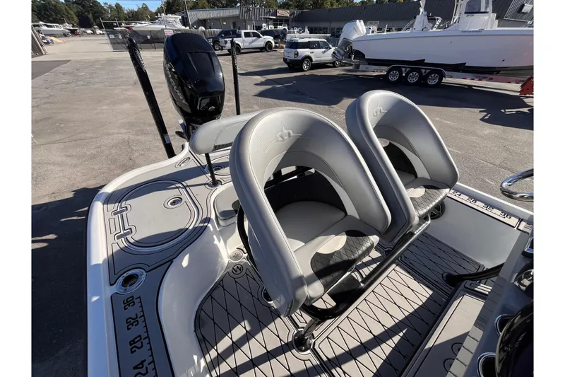 Slide: The Image of 2020 Turner Boatworks 2410 VS with dual seats and sleek design in a marina setting. - 7