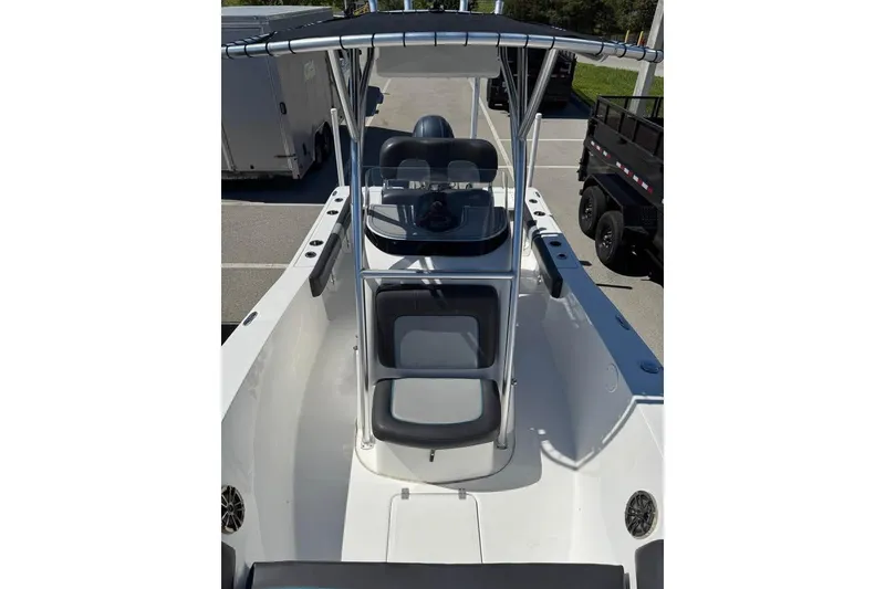 Slide: The Image of 2018 Sea Fox 206 Commander boat interior with seating and console, parked outdoors. - 5