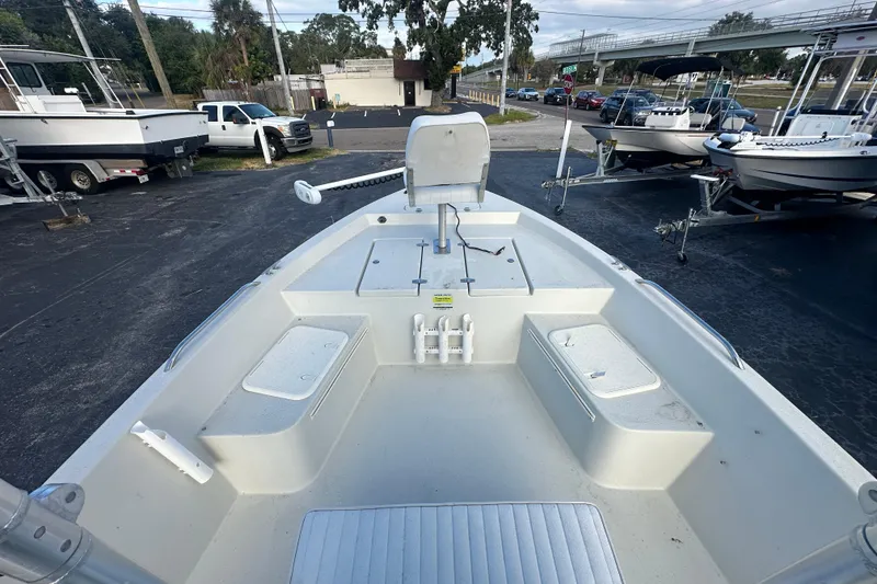 Slide: The Image of 2016 Stott Craft SCV202 boat interior with seating and storage, parked outdoors. - 14
