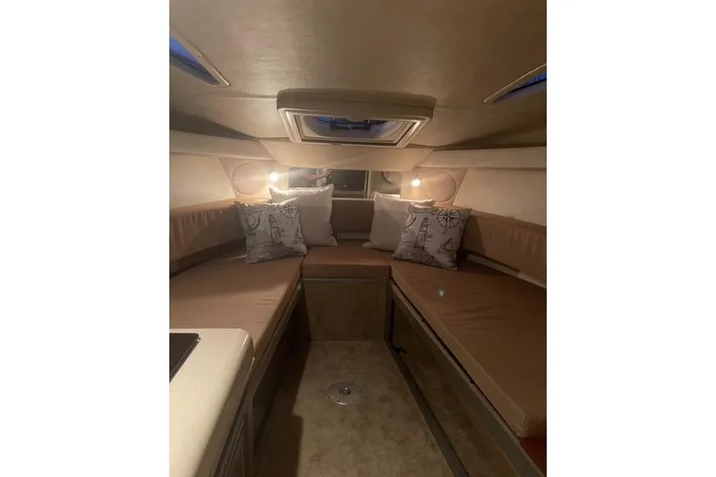 Slide: The Image of Interior cabin of 2012 Sea Ray 260 Sundancer with cozy seating and nautical-themed pillows. - 5