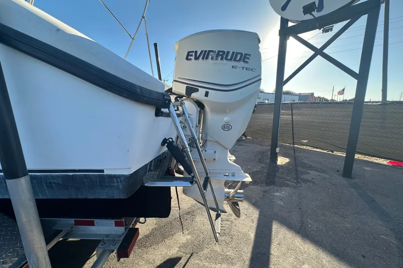 Slide: The Image of 2001 Boston Whaler 23 Conquest with Evinrude E-TEC outboard motor, parked on a trailer. - 12