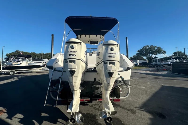 Slide: The Image of 2001 Boston Whaler 23 Conquest with dual Evinrude 150 engines, docked under clear sky. - 13