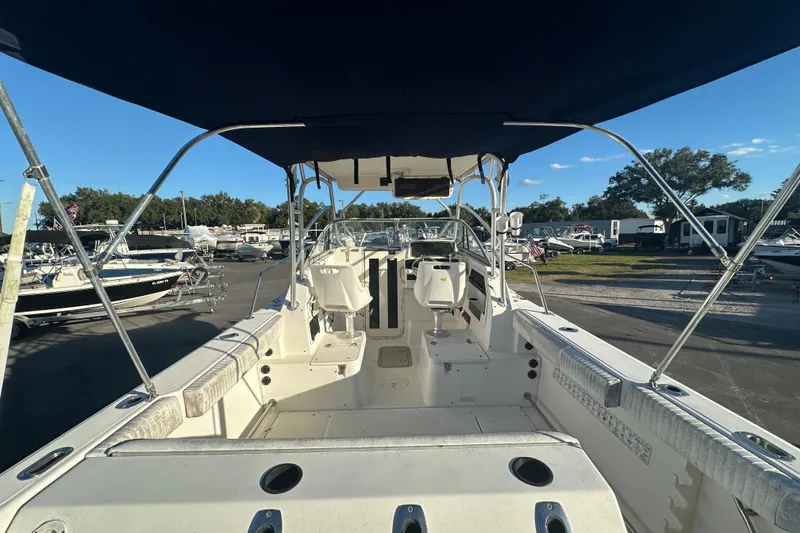 Slide: The Image of 2001 Boston Whaler 23 Conquest boat interior with canopy, docked in a marina. - 19