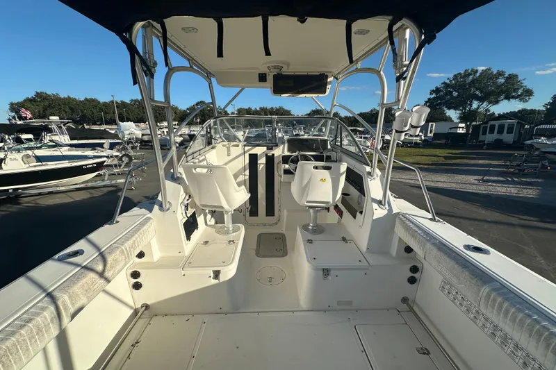 Slide: The Image of 2001 Boston Whaler 23 Conquest boat interior with seating and helm, docked outdoors. - 22