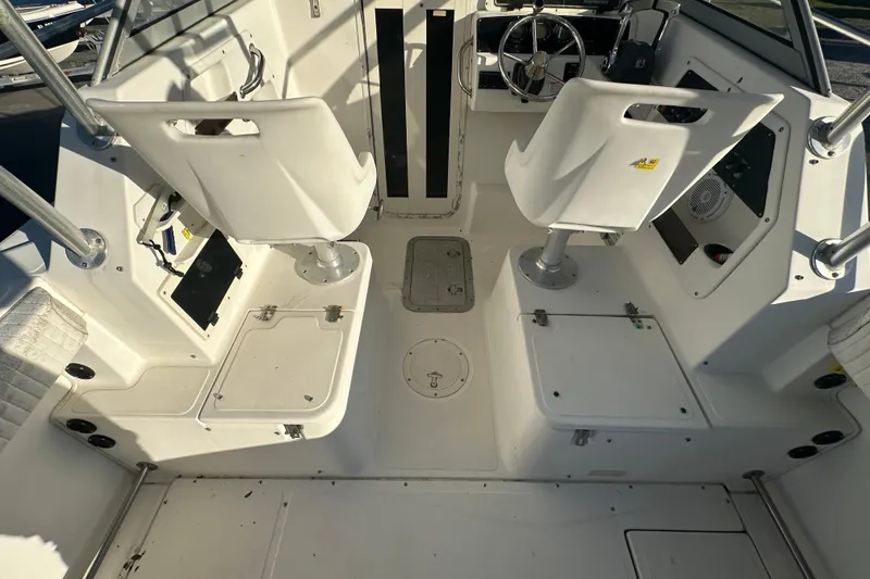 Slide: The Image of 2001 Boston Whaler 23 Conquest boat interior with white seating and control panel. - 26