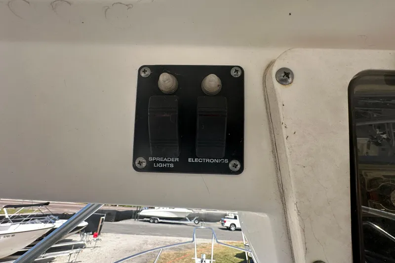 Slide: The Image of Control panel on a 2001 Boston Whaler 23 Conquest boat, featuring switches for spreader lights and electronics. - 29