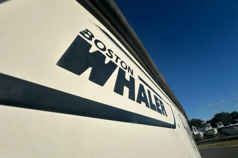 Slide: The Image of Close-up of 2001 Boston Whaler 23 Conquest logo on boat hull under clear sky. - 3