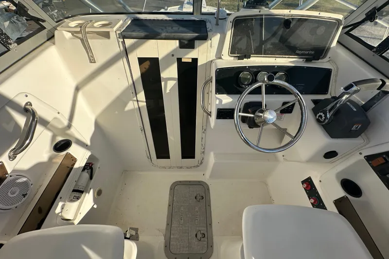 Slide: The Image of 2001 Boston Whaler 23 Conquest boat cockpit with steering wheel and control panel. - 34