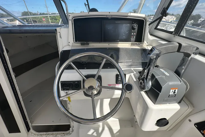 Slide: The Image of 2001 Boston Whaler 23 Conquest boat helm with steering wheel and control panel. - 36