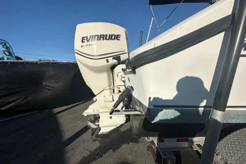 Slide: The Image of 2001 Boston Whaler 23 Conquest with Evinrude E-TEC outboard motor, parked on trailer. - 4