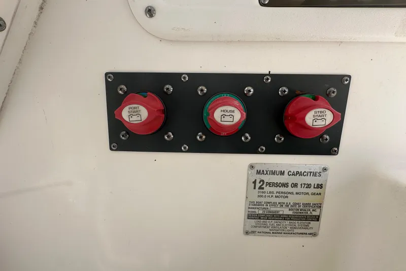 Slide: The Image of Control panel on a 2001 Boston Whaler 23 Conquest boat, showing battery switches and capacity label. - 47