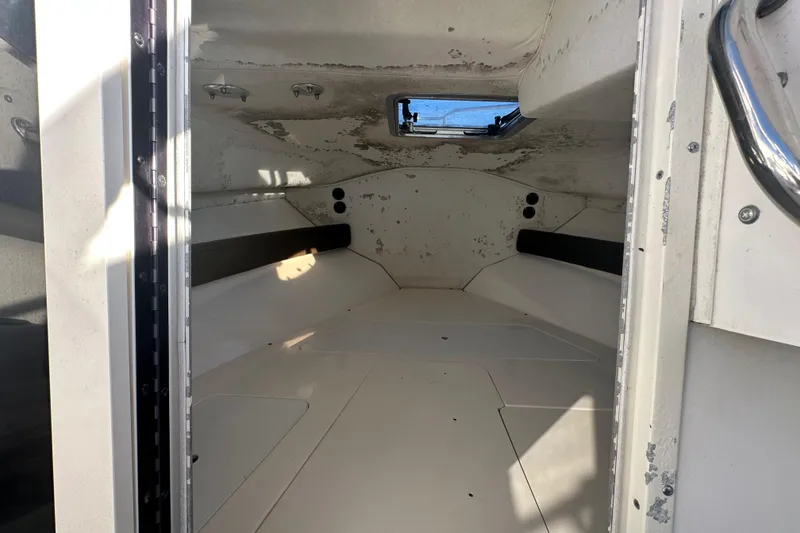 Slide: The Image of Interior cabin of a 2001 Boston Whaler 23 Conquest boat, showing seating and window. - 49