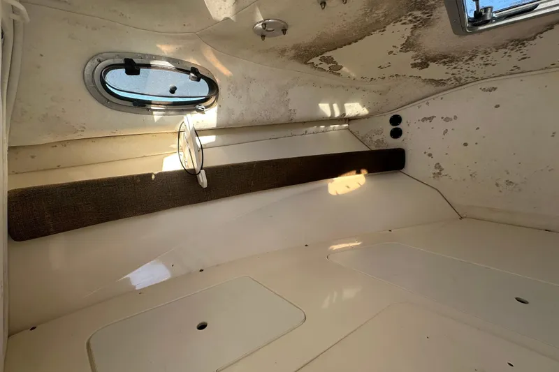Slide: The Image of Interior cabin of a 2001 Boston Whaler 23 Conquest boat, showing window and seating area. - 50