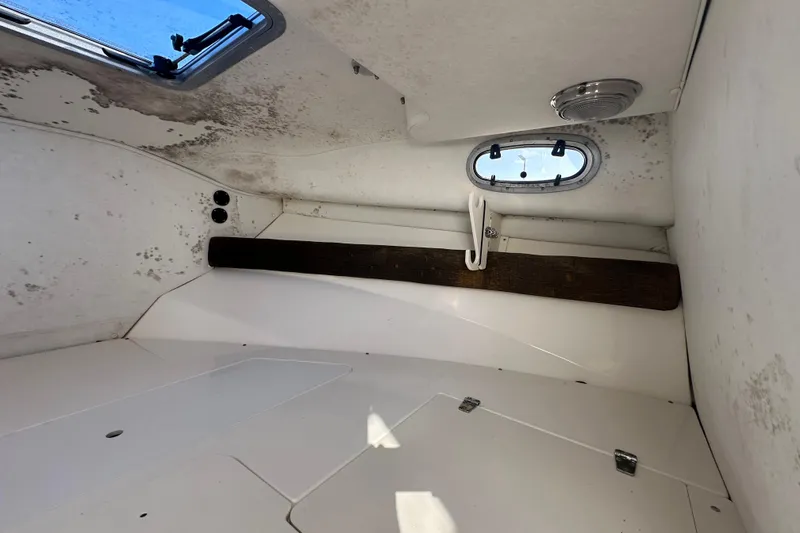 Slide: The Image of Interior cabin of a 2001 Boston Whaler 23 Conquest boat, showing window and storage area. - 52