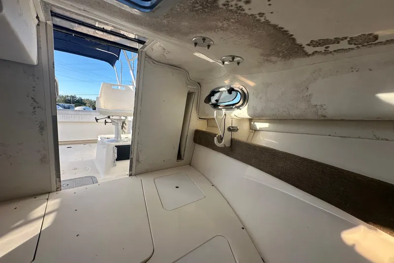 Slide: The Image of 2001 Boston Whaler 23 Conquest cabin interior with visible mold and open hatch. - 55