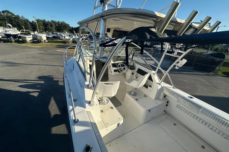 Slide: The Image of 2001 Boston Whaler 23 Conquest boat interior with helm and seating, docked outdoors. - 56