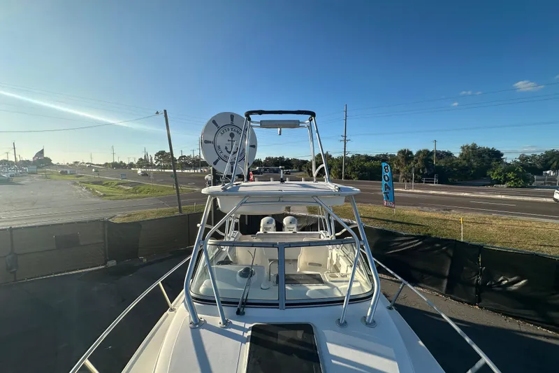 Slide: The Image of 2001 Boston Whaler 23 Conquest boat with tower, parked near a road under clear skies. - 67
