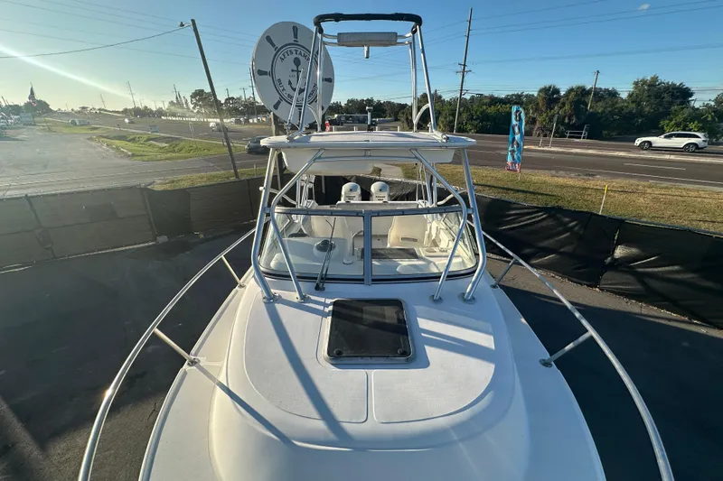 Slide: The Image of 2001 Boston Whaler 23 Conquest boat, docked, with clear skies and road in background. - 68