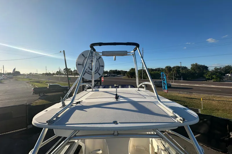 Slide: The Image of 2001 Boston Whaler 23 Conquest boat with radar, parked near a road under clear skies. - 70