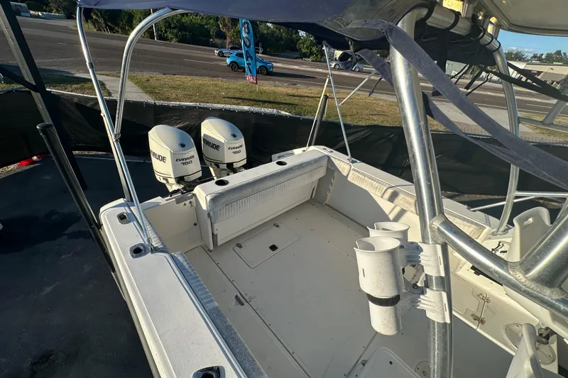 Slide: The Image of 2001 Boston Whaler 23 Conquest boat with dual Evinrude 150 engines, docked outdoors. - 76