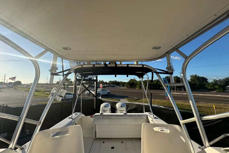 Slide: The Image of 2001 Boston Whaler 23 Conquest boat interior with dual engines, parked outdoors. - 77