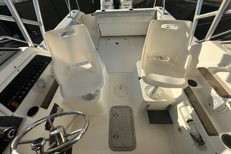 Slide: The Image of 2001 Boston Whaler 23 Conquest boat interior with steering wheel and seating area. - 79