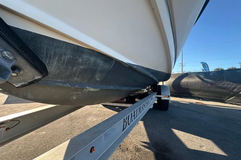 Slide: The Image of 2001 Boston Whaler 23 Conquest boat on trailer, viewed from below, in outdoor setting. - 8