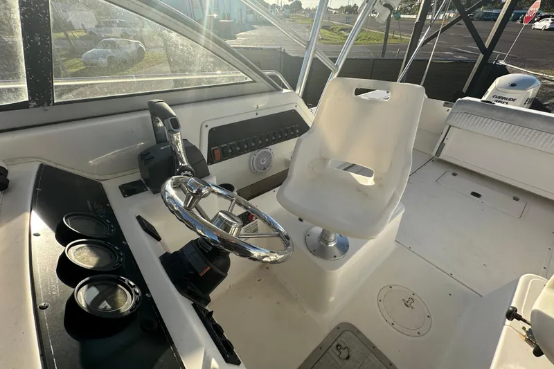 Slide: The Image of 2001 Boston Whaler 23 Conquest boat cockpit with steering wheel and control panel. - 80