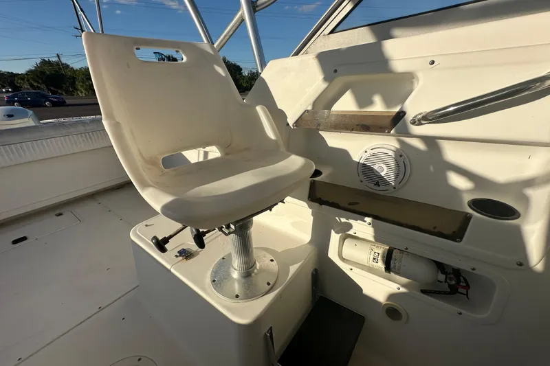 Slide: The Image of 2001 Boston Whaler 23 Conquest boat interior with captain's chair and control panel. - 83