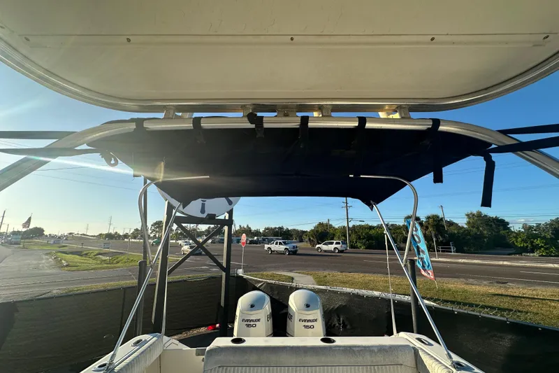 Slide: The Image of 2001 Boston Whaler 23 Conquest boat with Evinrude 150 engines, parked near a road. - 84