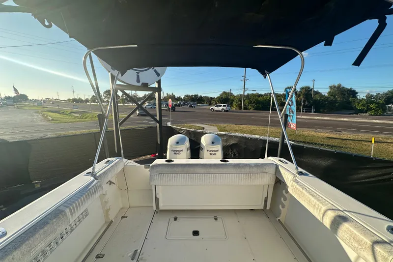 Slide: The Image of 2001 Boston Whaler 23 Conquest boat with dual Evinrude 150 engines, parked outdoors. - 85