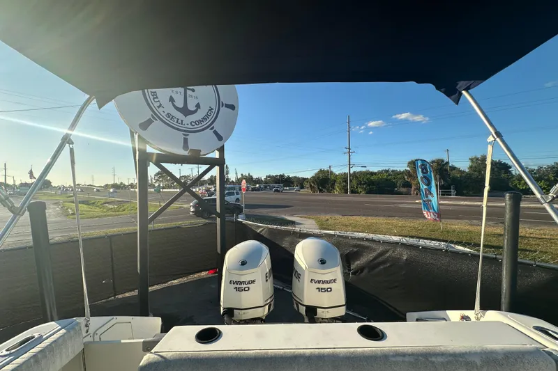 Slide: The Image of 2001 Boston Whaler 23 Conquest with dual Evinrude 150 engines, parked near a road. - 87