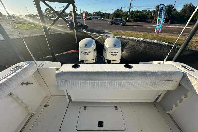 Slide: The Image of 2001 Boston Whaler 23 Conquest boat with dual Evinrude 150 engines, docked outdoors. - 88