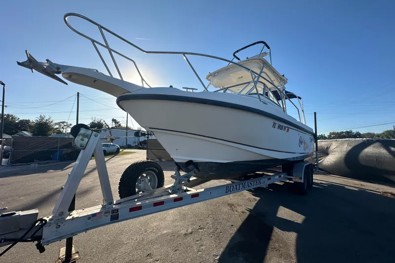 Slide: The Image of 2001 Boston Whaler 23 Conquest boat on trailer under clear blue sky. - 9
