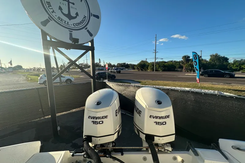 Slide: The Image of Twin Evinrude 150 engines on a 2001 Boston Whaler 23 Conquest boat, sunny day. - 90