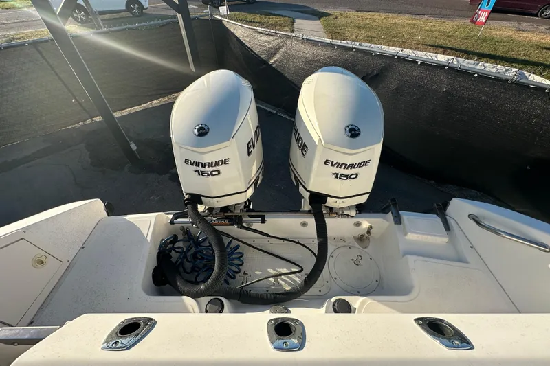 Slide: The Image of 2001 Boston Whaler 23 Conquest with dual Evinrude 150 engines, docked outdoors. - 91