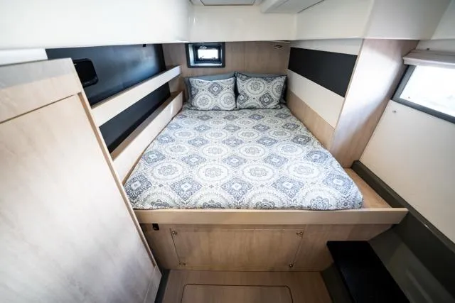 Slide: The Image of 2017 Leopard 51 Powercat cabin with patterned bedding and modern wood finish. - 120