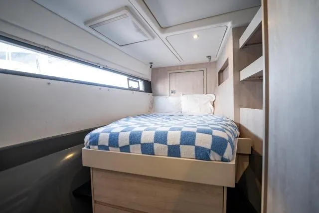 Slide: The Image of Cozy cabin interior of 2017 Leopard 51 Powercat with checkered bedding and modern design. - 134