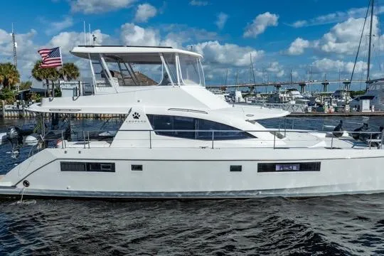 Slide: The Image of 2017 Leopard 51 Powercat yacht docked in marina, American flag, clear sky. - 141